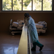 Respiratory therapist Babu Paramban talks on the phone next to hospital beds while taking a break in the COVID-19 unit at Providence Holy Cross Medical Center in the Mission Hills section of Los Angeles, Thursday, Nov. 19, 2020.